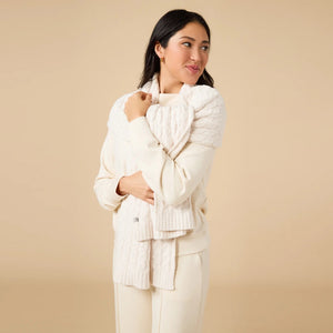 A woman wears a SOFTIES - DREAMTECH BOAT NECK WITH PINTUCK PANT SET in olive green, featuring a long-sleeve boat neck top and matching wide-leg pintuck pants.