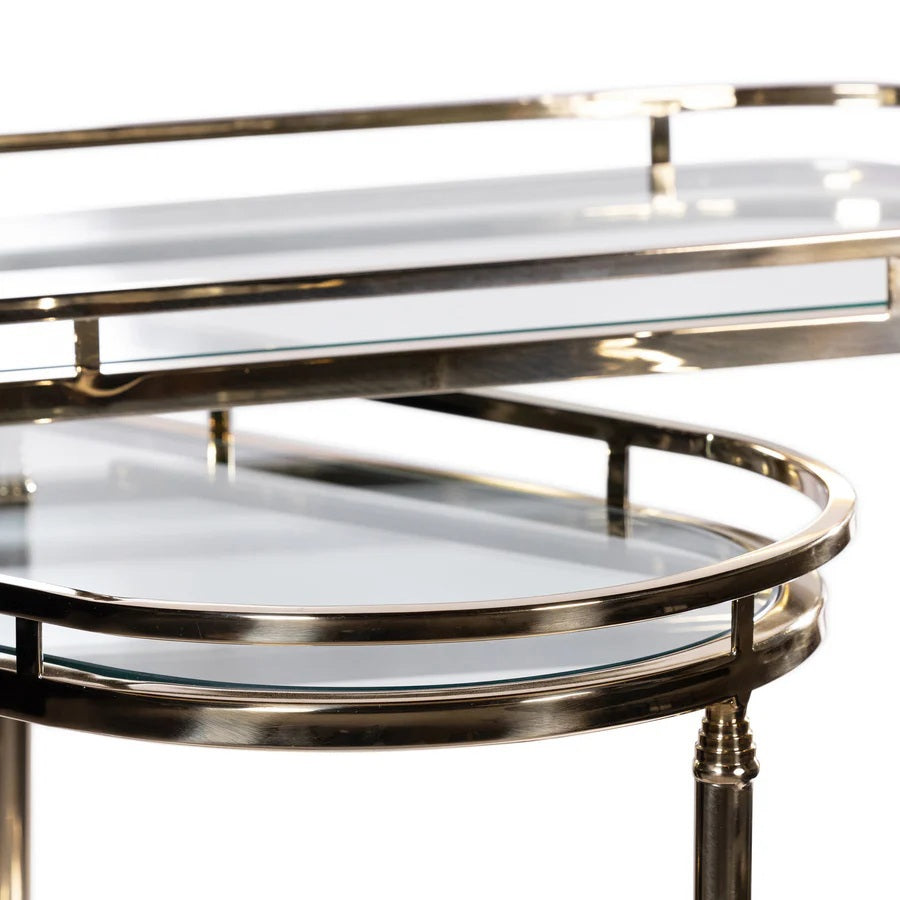 The SPIGA GOLD BAR CART by ZODAX features a vintage Italian-inspired design with elegant gold framing, mirrored glass shelves on both tiers, and smooth-rolling four-wheel mobility. Displayed against a white background, this piece is both stylish and functional.