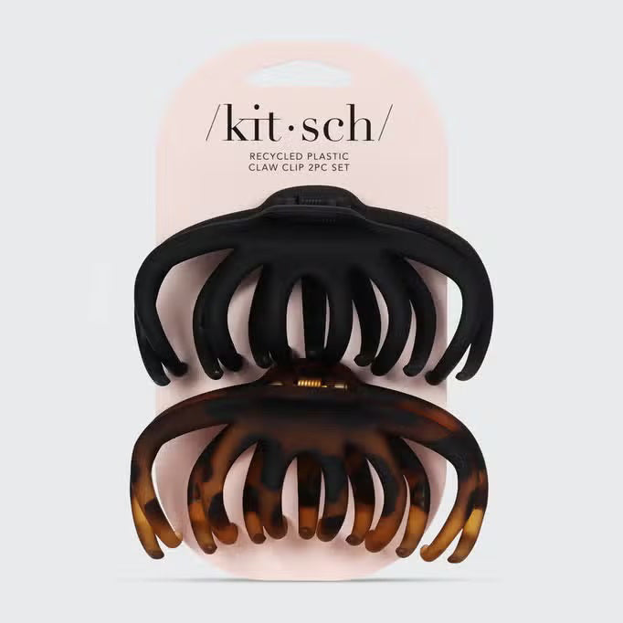 A white packaging card labeled "KITSCH" holds two claw clips: a black one and a tortoiseshell-patterned one. Called the "KITSCH - OCTOPUS CLAW CLIPS," this eco-friendly, recycled plastic 2-piece set combines sustainable fashion with practicality.
