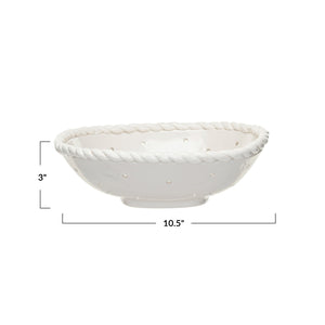The CREATIVE COOP STONEWARE COLANDER WITH HAND TWISTED EDGE, shown holding three grapefruits on a light textured surface, adds farmhouse charm to any kitchen.
