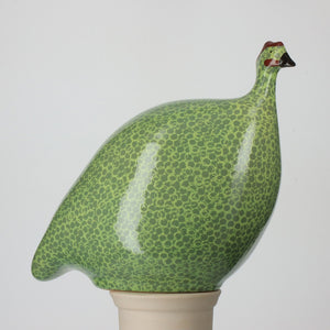 The LES CERAMIQUES DE LUSSAN - LARGE CERAMIC FRENCH GUINEA IN GREEN SPOTTED YELLOW is a handmade ceramic bird sculpture, inspired by guinea hens, featuring a rounded form and green dotted yellow glaze, crafted in the South of France.
