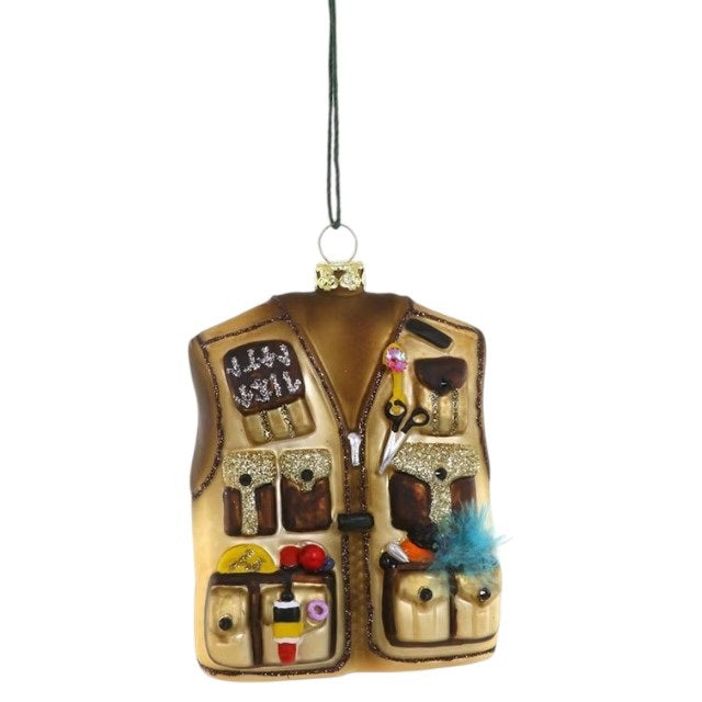 A 3-inch GLASS FLY FISHERMAN’S VEST ORNAMENT shaped like a tan vest, complete with multiple pockets, tools, and fishing gear attached.