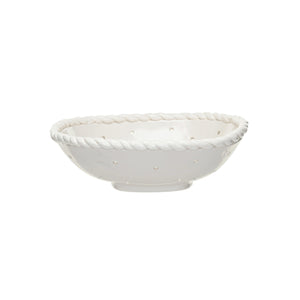 The CREATIVE COOP STONEWARE COLANDER WITH HAND TWISTED EDGE, shown holding three grapefruits on a light textured surface, adds farmhouse charm to any kitchen.