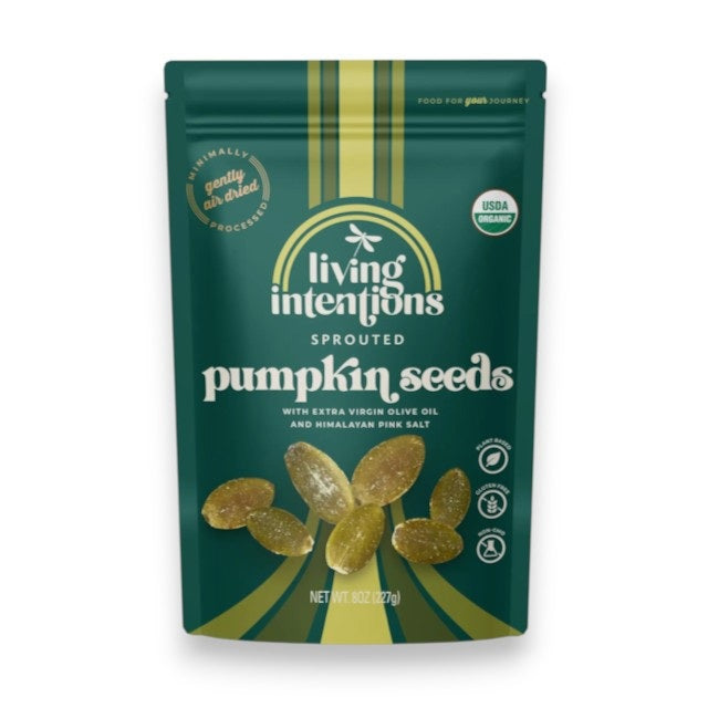 A beige and gold pouch of LIVING INTENTIONS - SALTED SPROUTED PUMPKIN SEEDS displays scattered sprouted pumpkin seeds on the front. The packaging highlights that this organic snack from LIVING INTENTIONS is made with Himalayan salt and features non-GMO, gluten-free, and USDA organic labels.