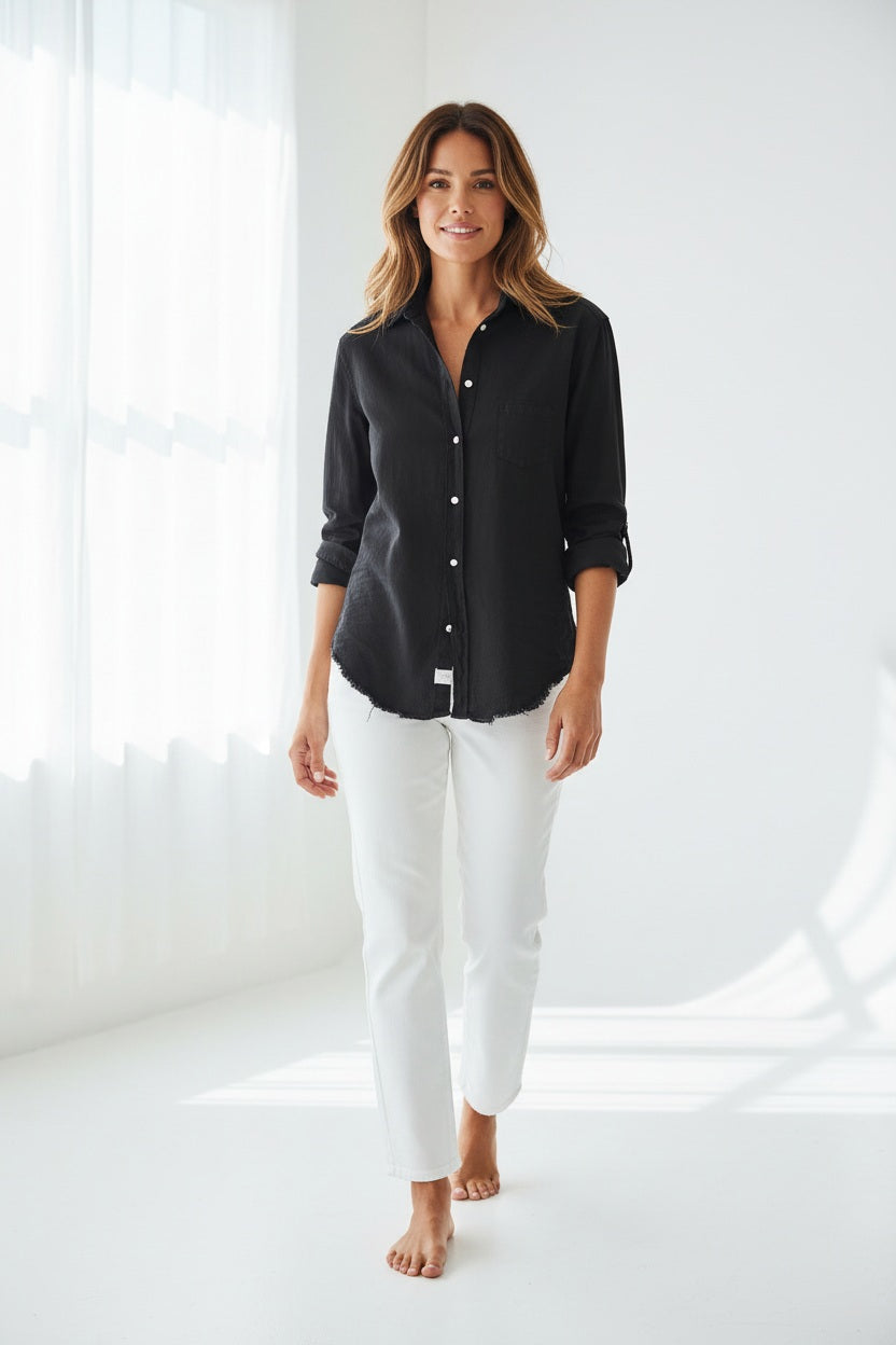 The FRANK &amp; EILEEN Eileen Relaxed Button-Up in Black Tattered Denim provides a relaxed fit with long sleeves that can be stylishly rolled up. It includes a single breast pocket on the left side and features a slightly curved hem, complemented by bust-enhancing button placement for added elegance.