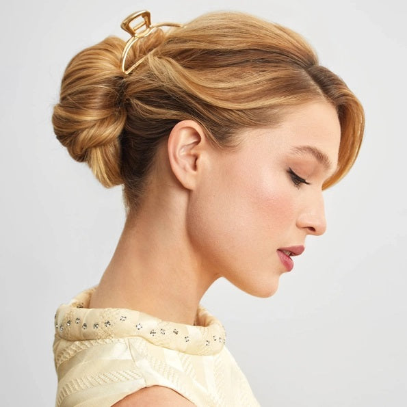 The KITSCH - OPEN SHAPE CLAW CLIP IN GOLD is a minimalist gold metal hair accessory from KITSCH, ideal for styling thick hair and showcased against a plain light background.
