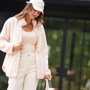 A woman wearing a cream SOFTIES - DREAMPLUSH DOUBLE ZIP JACKET / TUNIC with a cinched waist, paired with wide-leg denim culottes for cozy velvety softness.