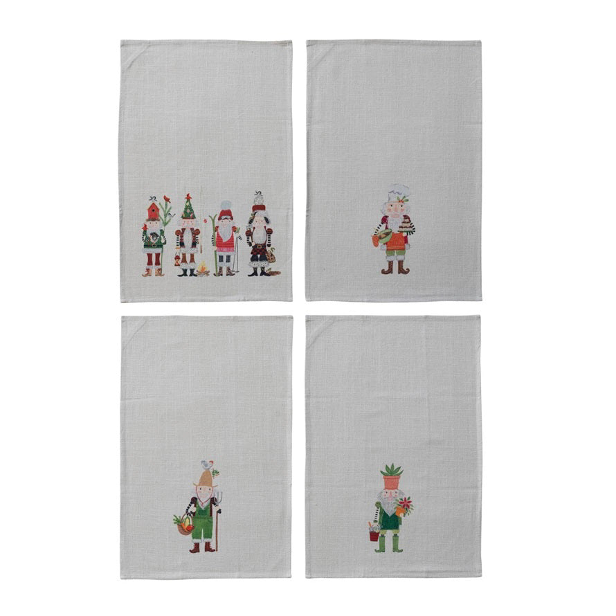 Four light gray CREATIVE COOP cotton slub tea towels are shown, each with festive embroidery—one features a row of Christmas characters, while the others display a nutcracker or holiday figure holding seasonal decorations.