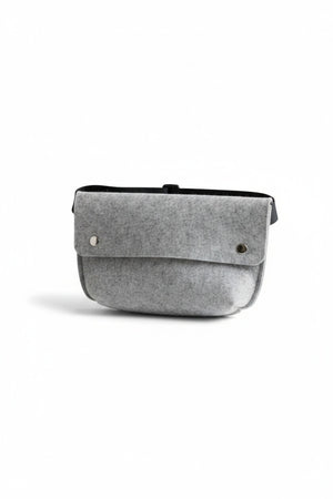 The WOOLBERRY - FELTED WOOL BELT BAG by WOOLBERRY is a small green belt bag crafted from felted wool, featuring a flap secured by two silver snap buttons, and is displayed against a white background.