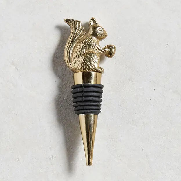 The BE HOME - SQUIRREL BOTTLE STOPPER by BE HOME, INC features a gold squirrel with an acorn atop a tapered metal base and black rubber rings—perfect for wine lovers.