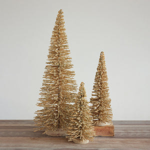 A handcrafted WOOD TREE WITH IRIDESCENT MICA FLAKES in the form of a gold-colored miniature tree covered in sparkling glitter.