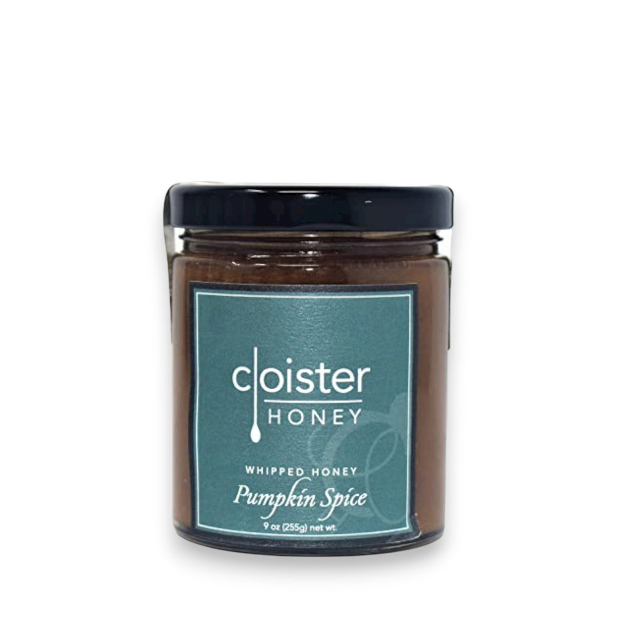 A jar of Cloister Honey&#39;s Whipped Honey Pumpkin Spice, adorned with a black lid and teal label, sits elegantly on a white surface. Its 9 oz (255g) size allows reflections to shimmer around its inviting charm.