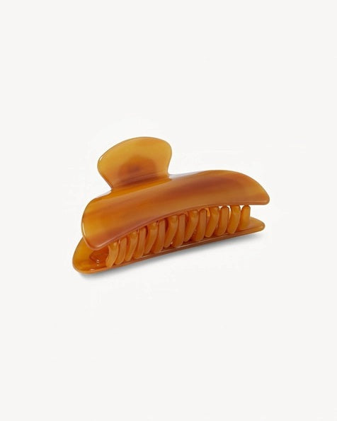 The MACHETE - MIDI HEIRLOOM CLAW by MACHETE is a pink and orange marbled hair claw clip, expertly crafted from premium Italian acetate. It features a curved design, wide grip, and interlocking teeth for a secure hold—ideal for medium volume hair. Shown against a plain white background.