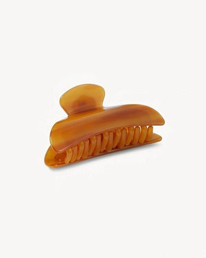 The MACHETE - MIDI HEIRLOOM CLAW by MACHETE is a pink and orange marbled hair claw clip, expertly crafted from premium Italian acetate. It features a curved design, wide grip, and interlocking teeth for a secure hold—ideal for medium volume hair. Shown against a plain white background.