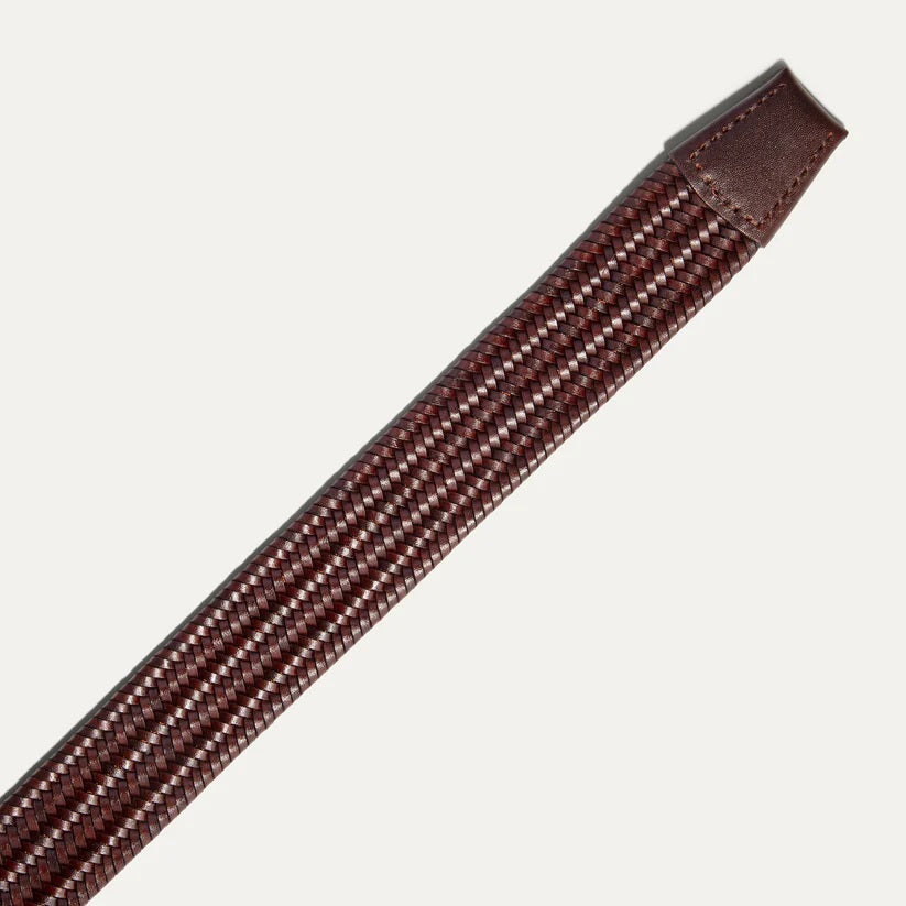 The WILL LEATHER GOODS - STRETCH BELT features a green, purple, and black braided design with full-grain leather accents by the silver buckle and tip, shown on a plain light background. Brand: WILL LEATHER GOODS.