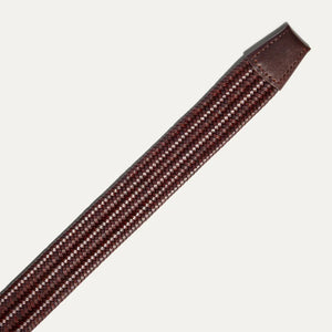 The WILL LEATHER GOODS - STRETCH BELT features a green, purple, and black braided design with full-grain leather accents by the silver buckle and tip, shown on a plain light background. Brand: WILL LEATHER GOODS.