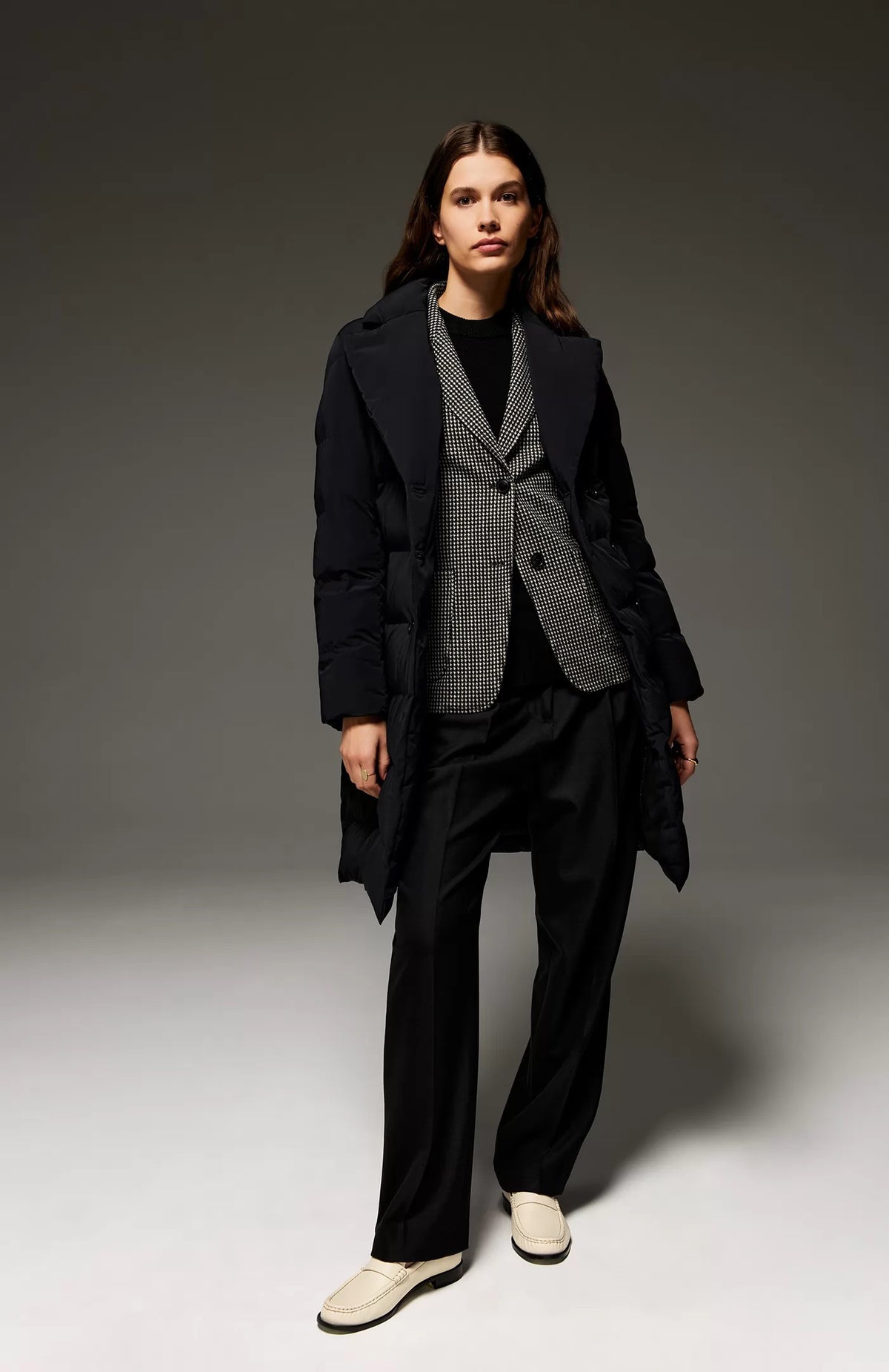 The SEVENTY Stretch Jacquard Vichy Jacket by SEVENTY is a tailored women&#39;s blazer featuring a classic black and white houndstooth pattern. Made in Italy, it boasts a notched lapel, two large black buttons for closure, and front flap pockets. The inner lining is dark grey, complementing its overall structured design.