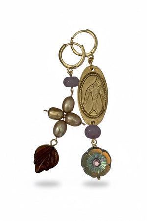 SANDRINE FRANCE STUDIO - HOLLY EARRINGS: Handmade in NYC, these mismatched gold-plated brass earrings feature unique designs—one earring showcases pearls, a brown seashell bead, and a pink bead; the other is adorned with an engraved oval gold charm, a pink bead, and a round faceted clear bead with an intricate floral motif.