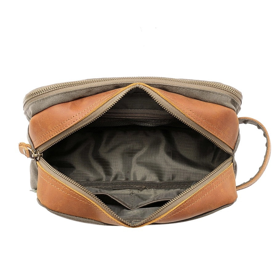 The TSD BRAND Turtle Ridge Toiletry Bag in Olive features leather accents and durable waxed canvas. Grooming essentials fit neatly in elastic loops and mesh pockets, making it the perfect travel companion.