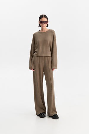 The ELEH - THE SCALA SWEATSHIRT by ELEH is a taupe, long-sleeve cropped sweatshirt featuring dropped shoulders and a relaxed fit, shown against a plain white background.
