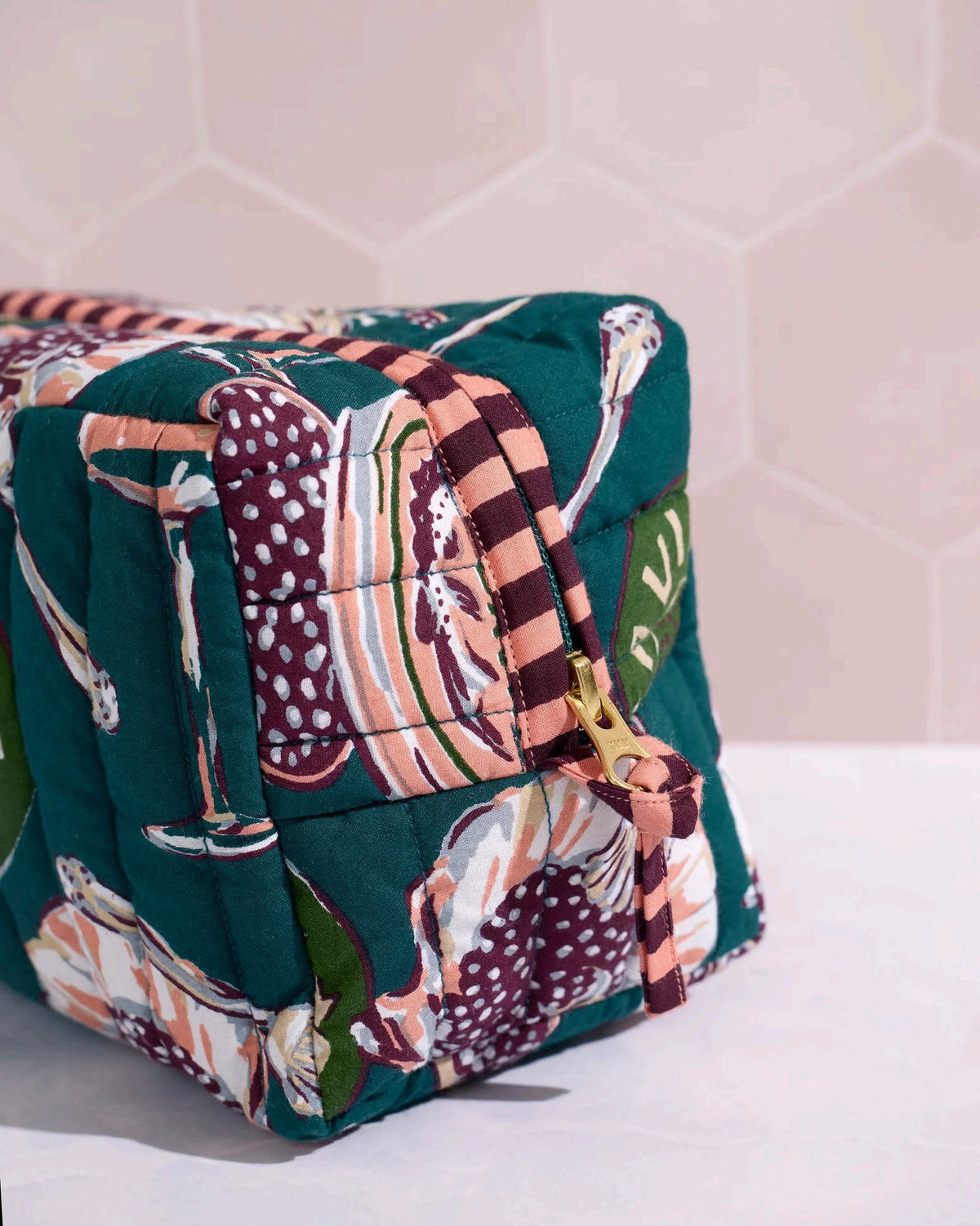 Adorned with an illustrated pattern of caviar tins, open shells brimming with caviar, delicate spoons, and tall champagne glasses on a rich peacock feather green background, the PRINTFRESH - CHAMPAGNE & CAVIAR QUILTED POUCH IN PEACOCK FEATHER is an elegant accessory from PRINTFRESH. This stylish pouch makes a perfect gift for her.