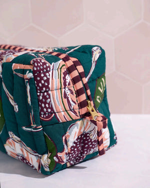 Adorned with an illustrated pattern of caviar tins, open shells brimming with caviar, delicate spoons, and tall champagne glasses on a rich peacock feather green background, the PRINTFRESH - CHAMPAGNE & CAVIAR QUILTED POUCH IN PEACOCK FEATHER is an elegant accessory from PRINTFRESH. This stylish pouch makes a perfect gift for her.