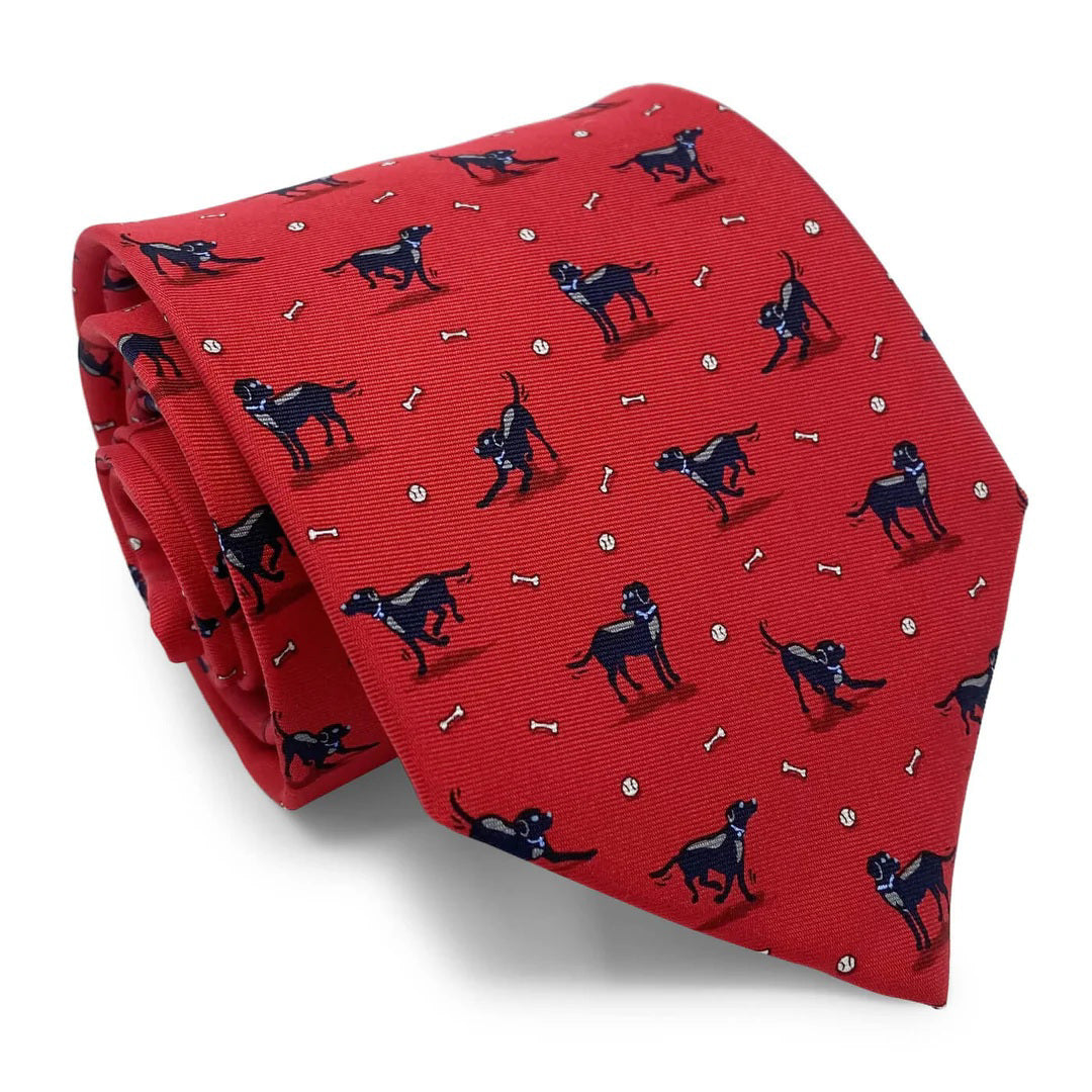 The BIRD DOG BAY - BLACK LAB TIE by BIRD DOG BAY is a blue necktie handmade in New York, featuring black Labrador dogs, white bones, and small white balls.
