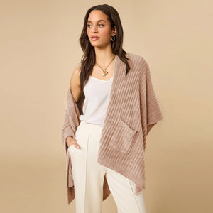 A woman wearing a black SOFTIES - SOLID RIB MARSHMALLOW SHAWL over a grey top and white trousers.