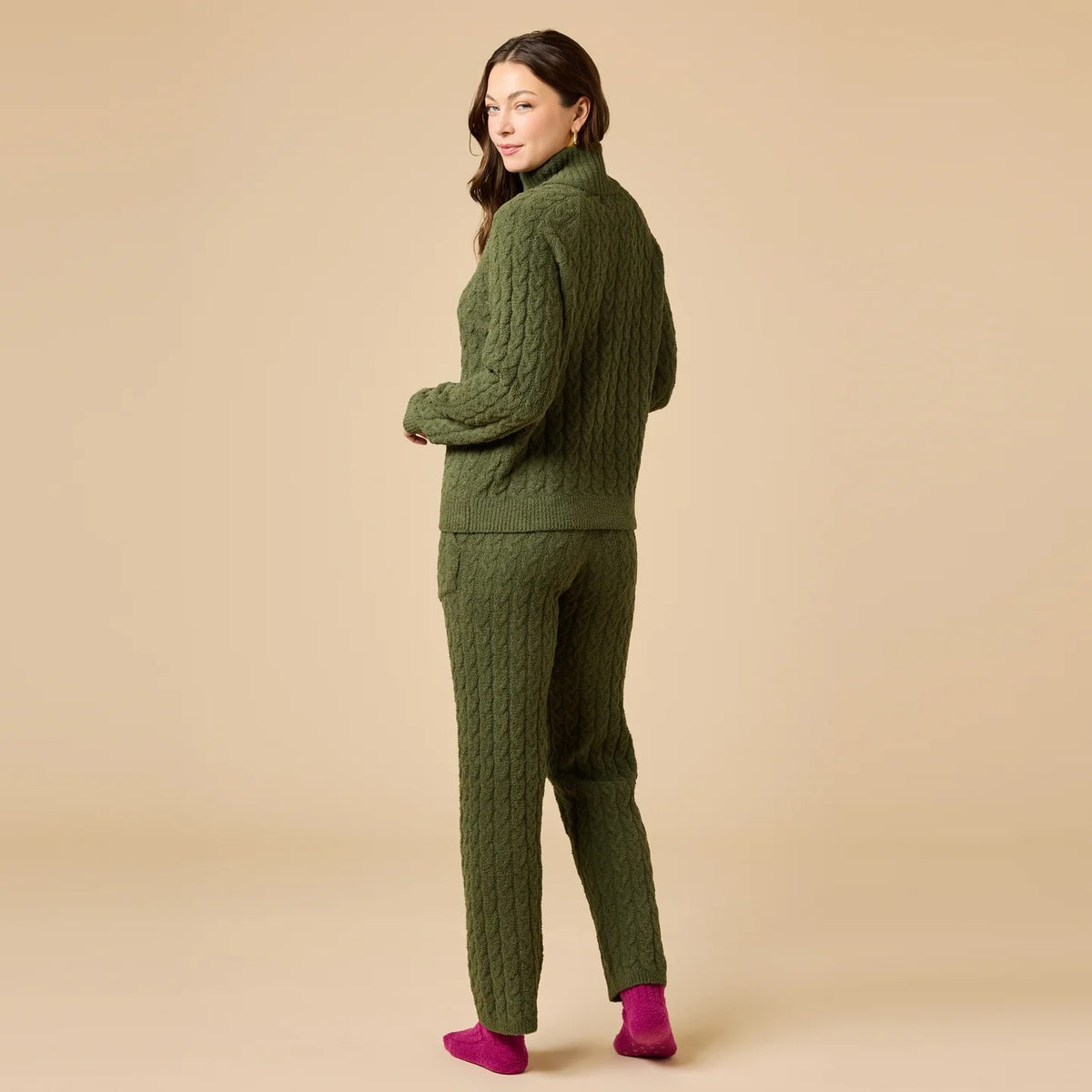 A woman wearing a marshmallow-soft, cream-colored SOFTIES - CABLE KNIT MARSHMALLOW ½ ZIP WITH TAPERED PANT SET, featuring a half-zip pullover and matching pants with a drawstring waist.