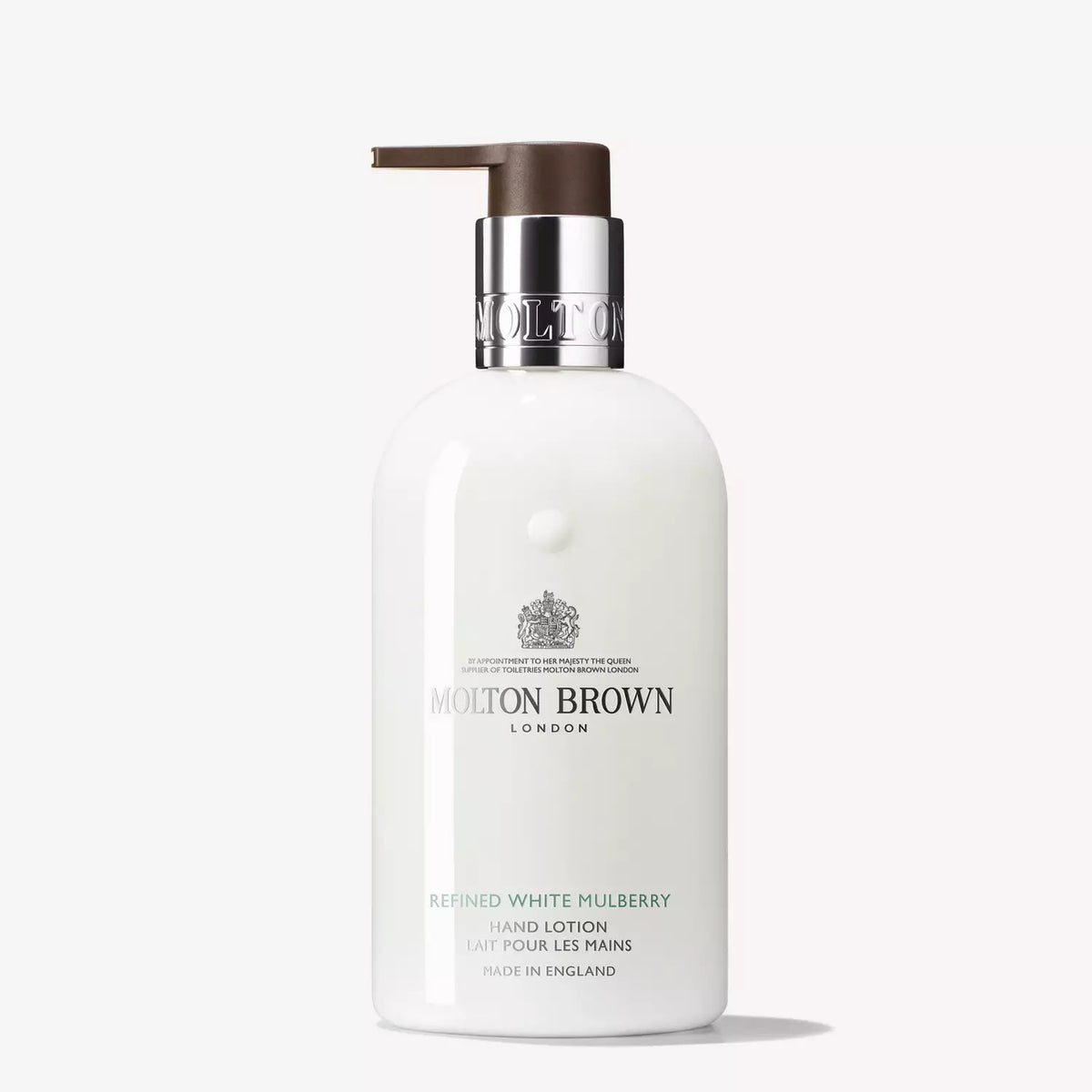 A white bottle of Molton Brown White Mulberry and Thyme Hand Lotion featuring a silver pump dispenser. The label reads "Molton Brown London" and "White Mulberry and Thyme Hand Lotion" with additional text "Made in England." Enjoy the aromatic essence and keep your hands feeling freshly moisturised.