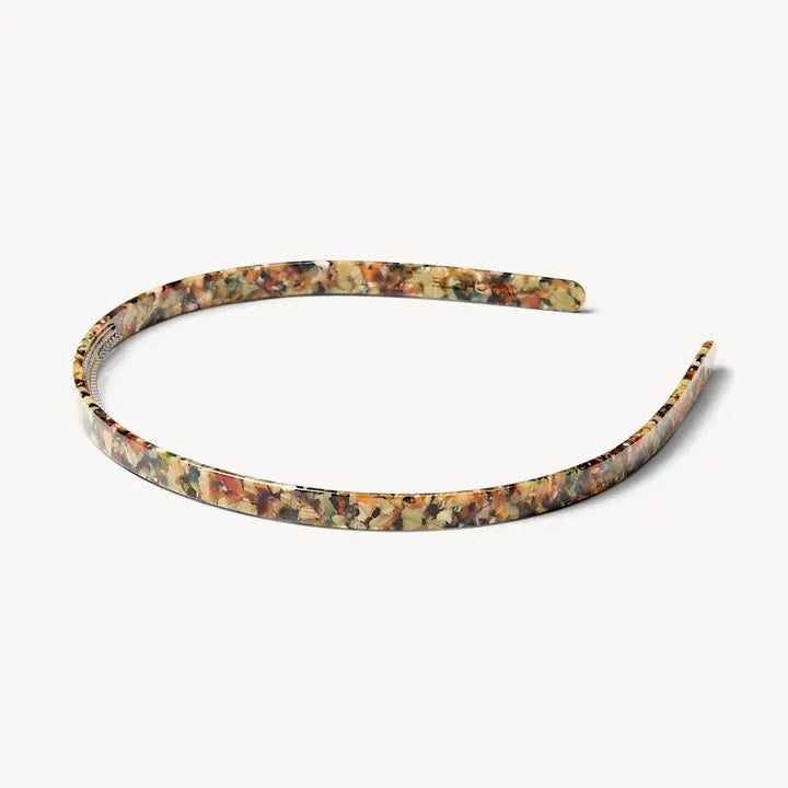 The MACHETE Ultralight Thin Headband in Monet, featuring a multicolored marbled pattern, rests on a plain light background.