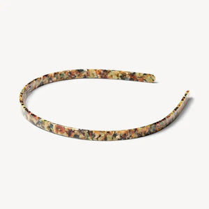 The MACHETE Ultralight Thin Headband in Monet, featuring a multicolored marbled pattern, rests on a plain light background.