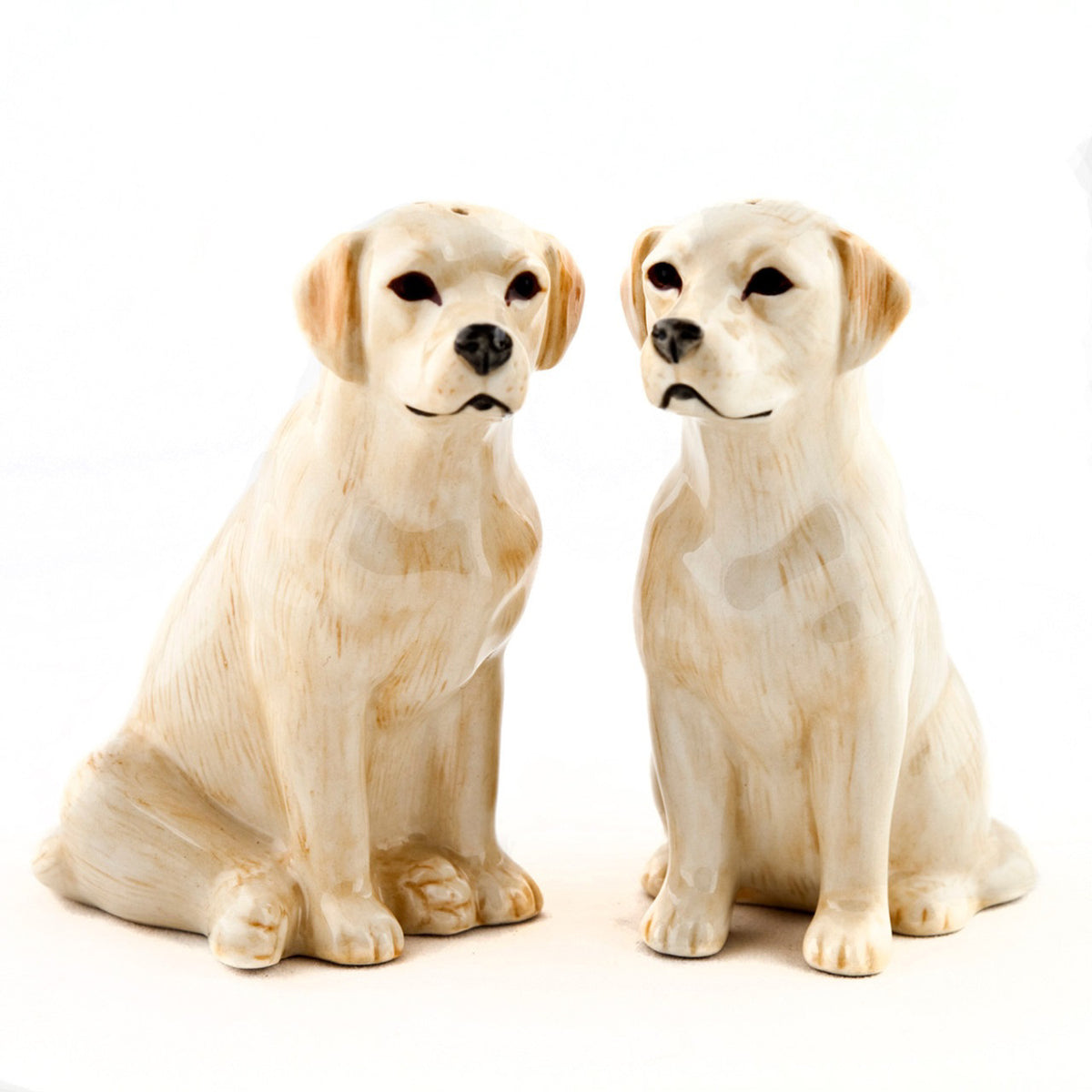 The QUAIL CERAMICS - GOLDEN LABRADOR SALT AND PEPPER SET by QUAIL DESIGNS features two handpainted stoneware golden Labradors with realistic details and a glossy finish, perfect for adding charm to your table.