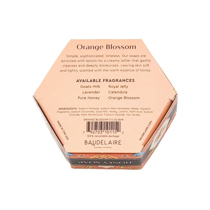 BAUDELAIRE - ORANGE BLOSSOM HONEY SOAP 3.5 OZ, HEX BOX features orange and cream packaging with intricate floral designs, a circular cutout revealing the soap inside, and a white label adorned with an orange blossom illustration.