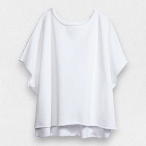 The FRANK & EILEEN Olive Original Capelet in white, a 100% cotton T-shirt with short sleeves and a wide neckline, hangs against a textured light gray background.