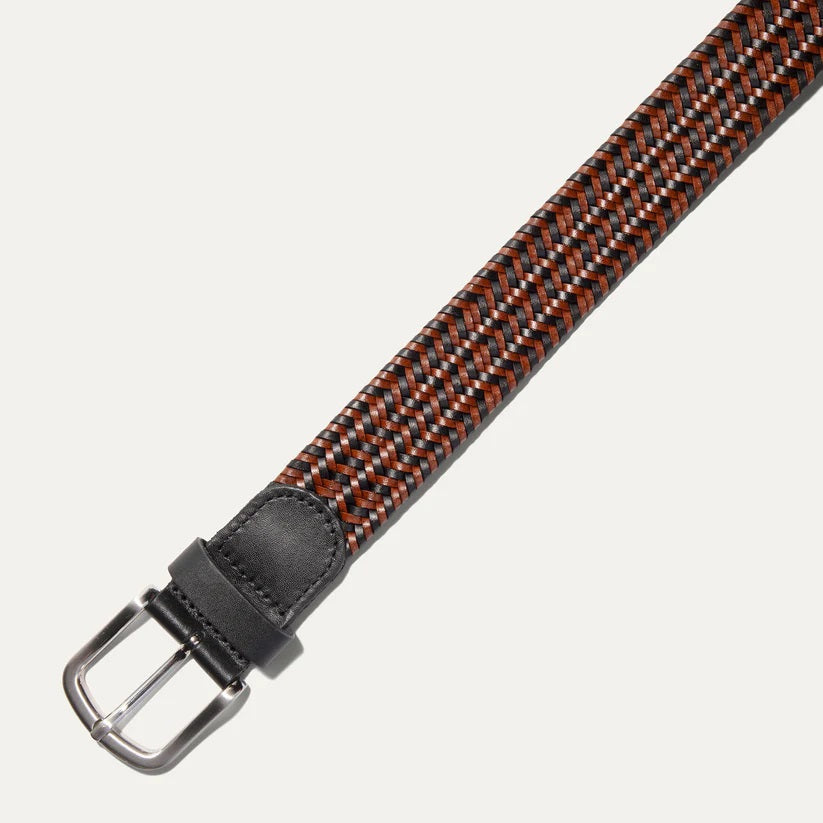 The WILL LEATHER GOODS - STRETCH BELT features a green, purple, and black braided design with full-grain leather accents by the silver buckle and tip, shown on a plain light background. Brand: WILL LEATHER GOODS.
