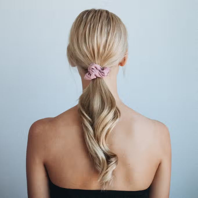 The KITSCH Velvet Scrunchies, perfect hair accessories in dusty pink and sage green, boast a soft texture. They come elegantly gathered on a white card labeled "KITSCH" with "SCRUNCHIE" below.