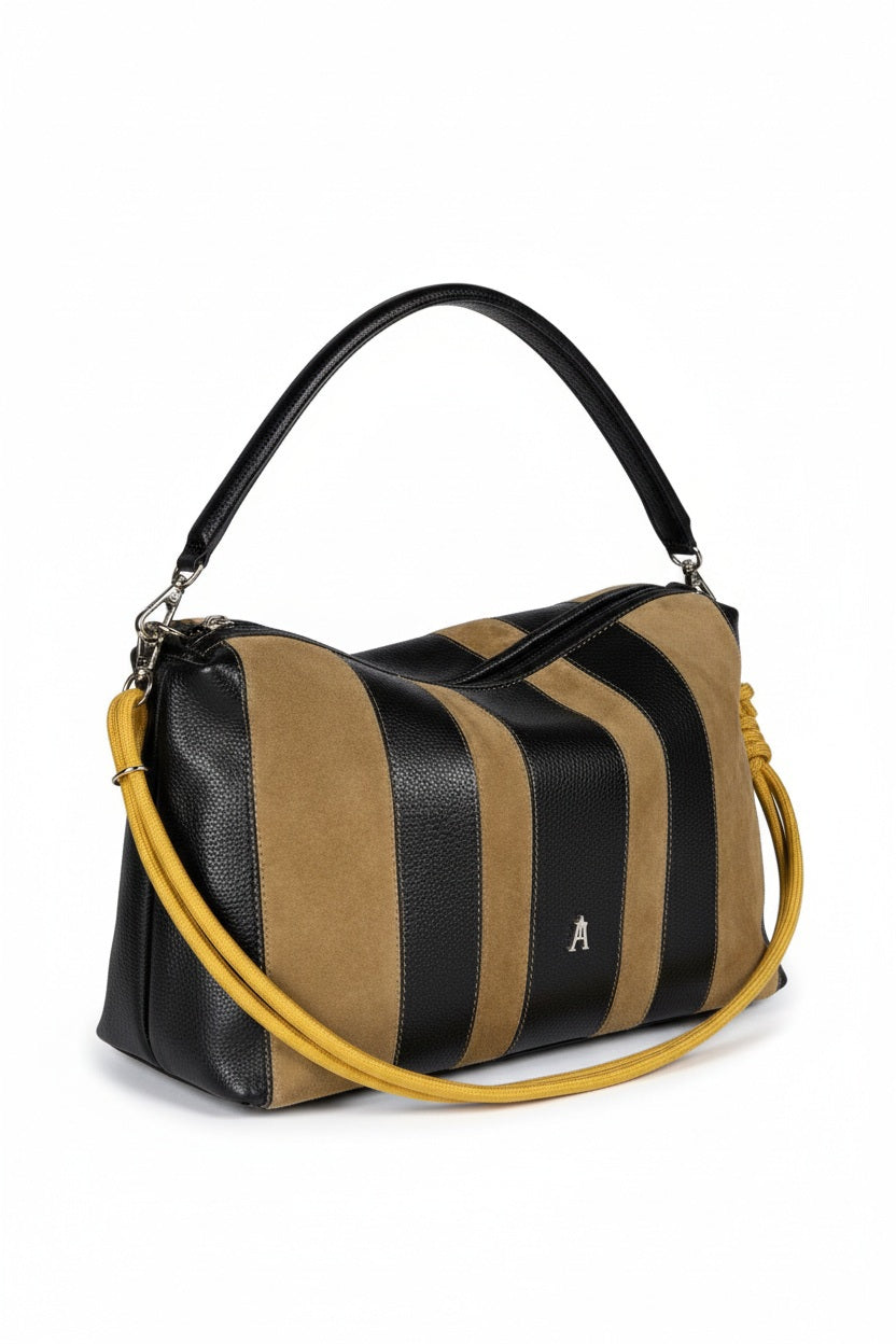 The CRAIE STUDIO HALO STRIPE NOIR SEPIA handbag features black and tan vertical stripes, a black handle, a yellow knotted shoulder strap, and a subtle silver logo on the front. Expertly crafted from grained leather by CRAIE STUDIO, this bag showcases a modern, structured silhouette that enhances its sophisticated allure.