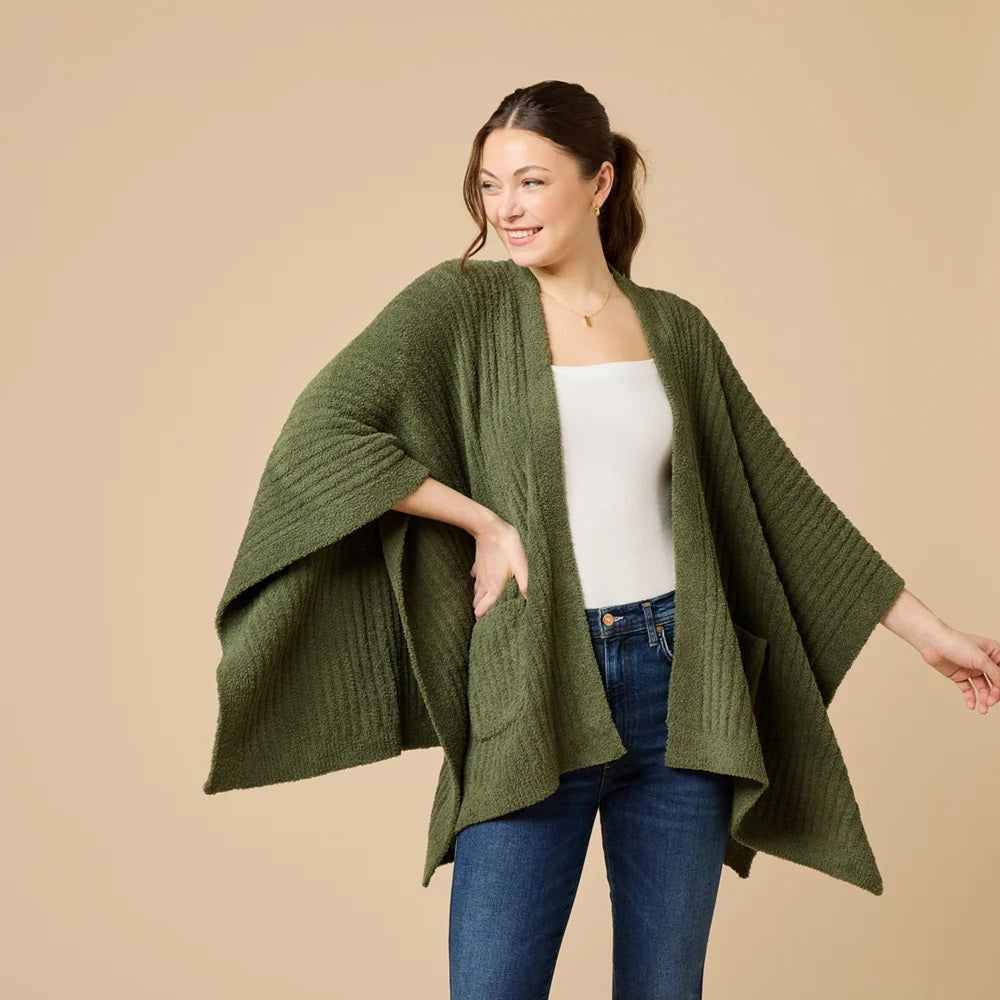 A woman wearing a black SOFTIES - SOLID RIB MARSHMALLOW SHAWL over a grey top and white trousers.