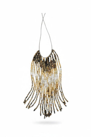 A mannequin wears a textured, curly taupe jacket and the ANN LIGHTFOOT Tiger Eye and Quartz Ombre Cascade Necklace, featuring dramatic dark beaded fringes in a triangular shape. The softly blurred background is neutral.