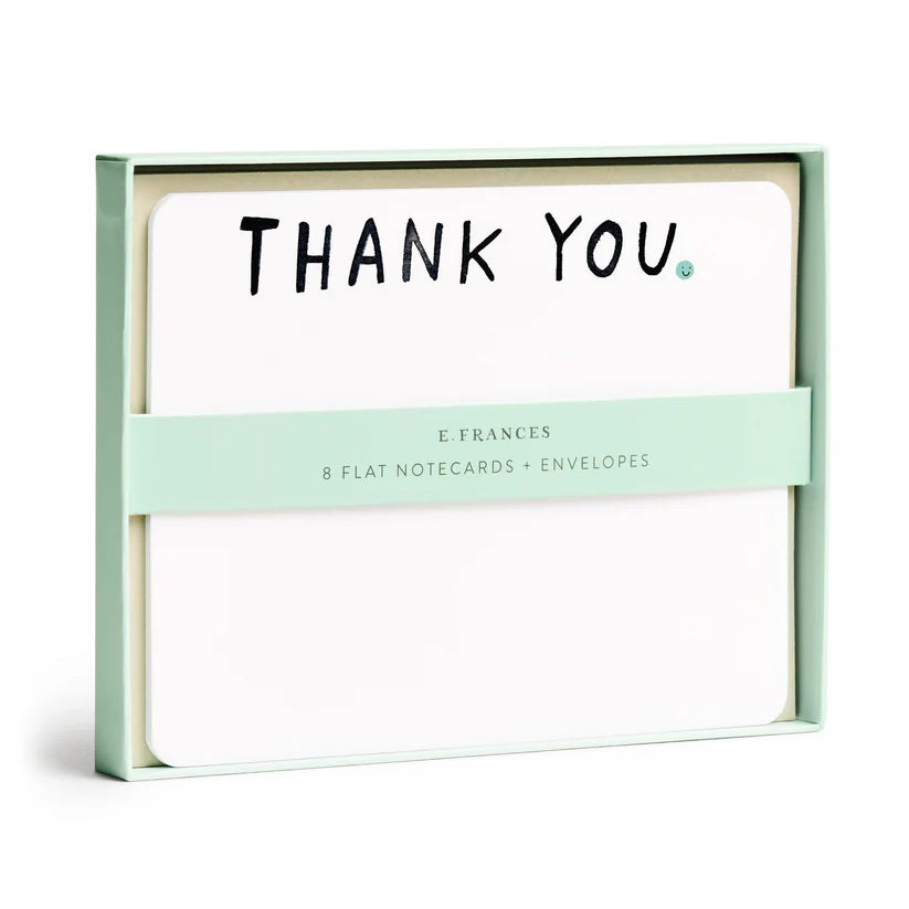A set of 8 E. FRANCES PAPER "THANK YOU" flat notes features elegant watercolor designs with bold black lettering. Each card comes with an envelope, wrapped in a light green band labeled "E. Frances.