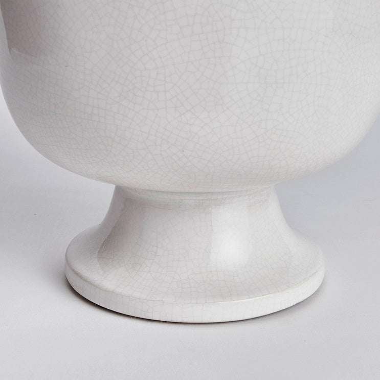 A photograph of the NAPA HOME AND GARDEN - ALBIE FOOTED CACHEPOT, a traditional white ceramic pedestal bowl with a textured, crackled finish. It features a smooth, glossy surface on a wide base, perfect for enhancing any home decor as a centerpiece.