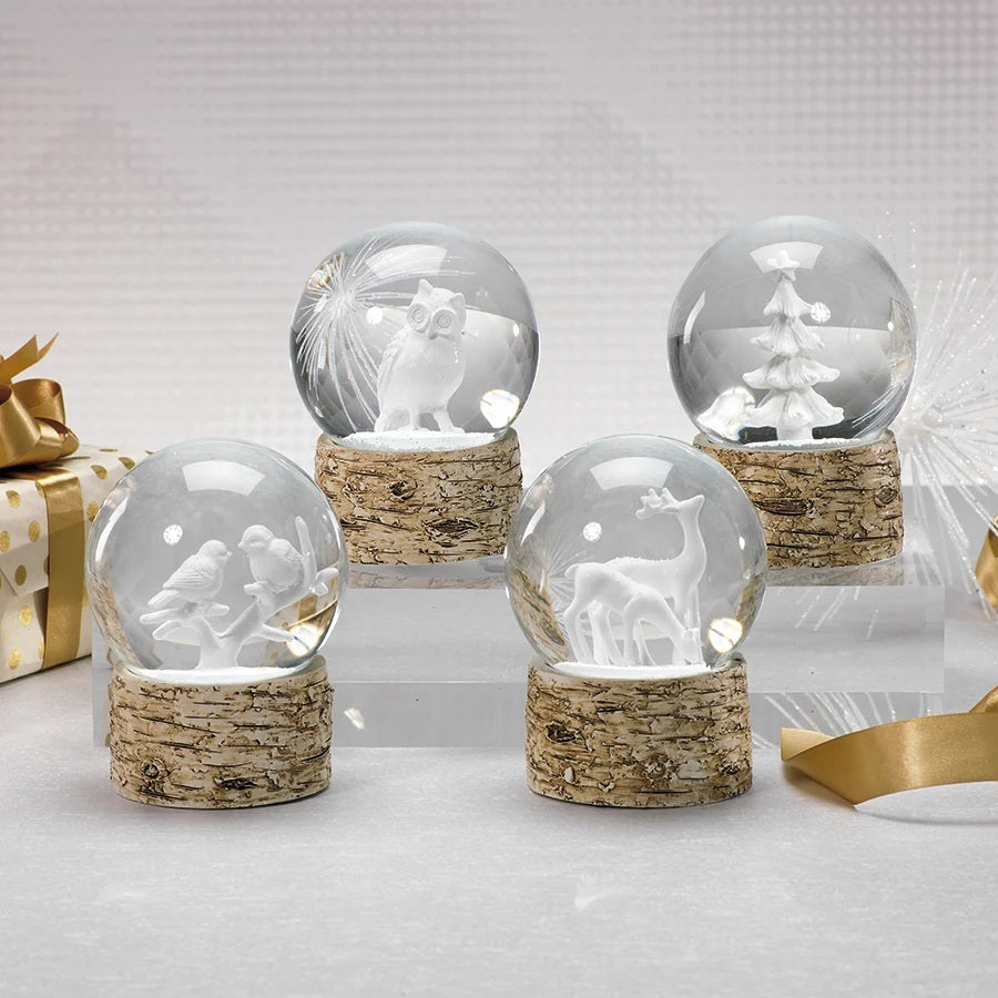 ZODAX SNOW GLOBE ON BIRCH WITH WHITE REINDEERS featuring two reindeer figures inside a glass globe set on a cylindrical, bark-textured birch base.