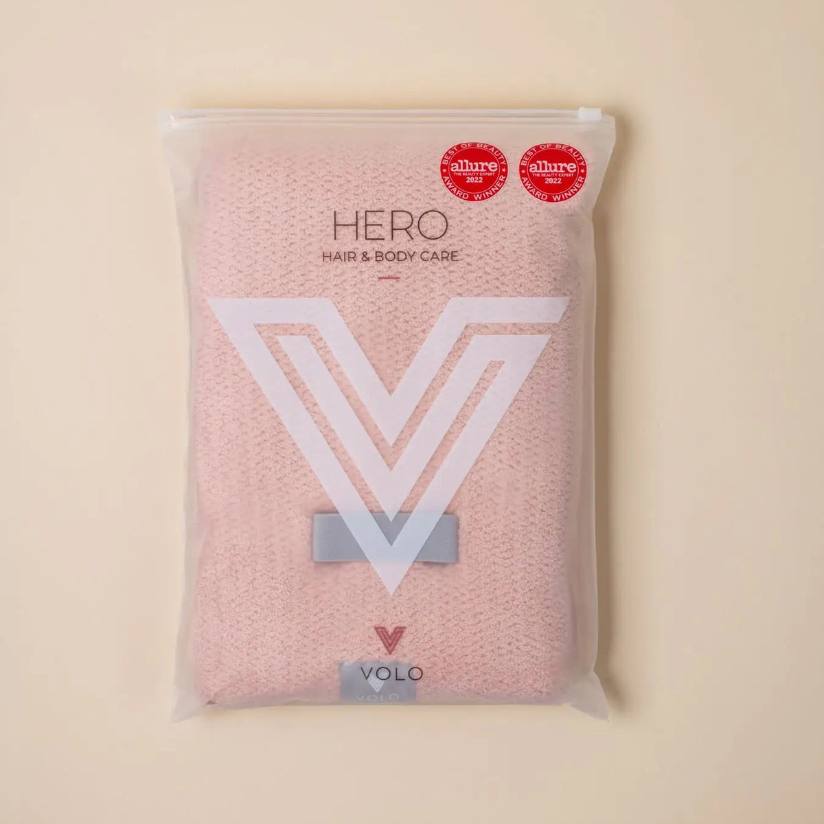 A packaged VOLO BEAUTY HAIR HERO TOWEL with soft Nanoweave fabric is in a clear bag, showing two Best of Beauty awards on the top right, set against a beige background.