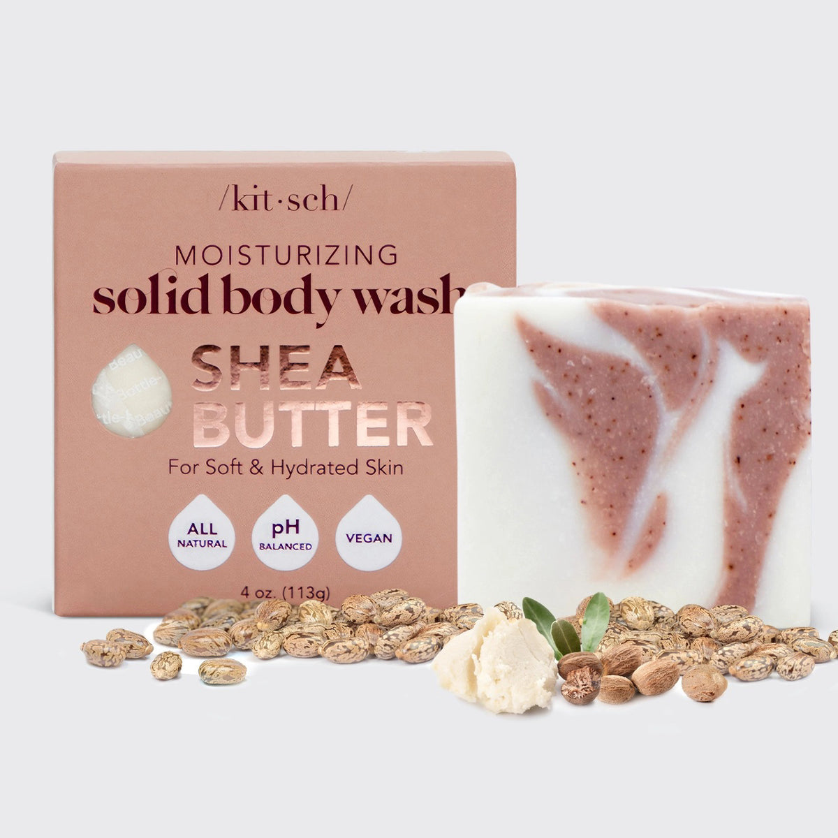 A bar of KITSCH - MOISTURIZING SHEA BUTTER BODY WASH with pink and white swirls rests on a pink box; this all-natural, pH balanced, vegan body wash leaves skin soft and hydrated.