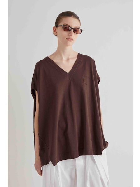 A person wearing dark sunglasses, white pants, and the MEIMEIJ Oversized Cotton T-shirt in White with a boxy silhouette and short sleeves stands against a plain light background, hair pulled back.