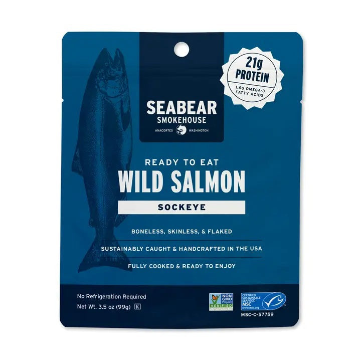 A package of SEABEAR SMOKEHOUSE Ready-To-Eat Sockeye Salmon, featuring a fish illustration and a window displaying the wild-caught jerky inside, is labeled “Traditional” and provides 35g of protein per bag.