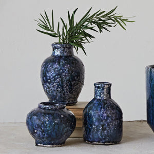 The CREATIVE COOP Decorative Terracotta Vase with Blue Crackle Glaze, Small, features a round, wide-mouthed design and glossy marbled blue-black finish with subtle white speckles, shown against a plain white background.