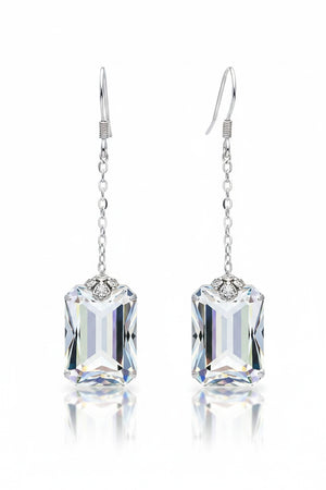 The VERDIER - SWAROVSKI EMERALD CUT CRYSTAL EARRINGS by VERDIER feature sterling silver hooks and rectangular, emerald cut crystals inspired by the Swarovski Aurora design, delicately suspended from fine chains and elegantly presented against a white background.