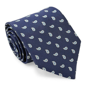 A rolled-up PETER-BLAIR - CAPE COD SILK TIE IN NAVY AND BLUE by BIRD DOG BAY, handmade in New York, featuring a navy blue silk fabric with a repeating light blue and white paisley pattern, displayed on a white background.